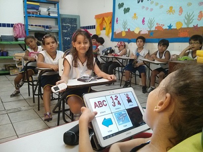 Crianças em sala de aula utilizando o aplicativo Livox